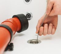 process of drain cleaning of the bathtub using special tools