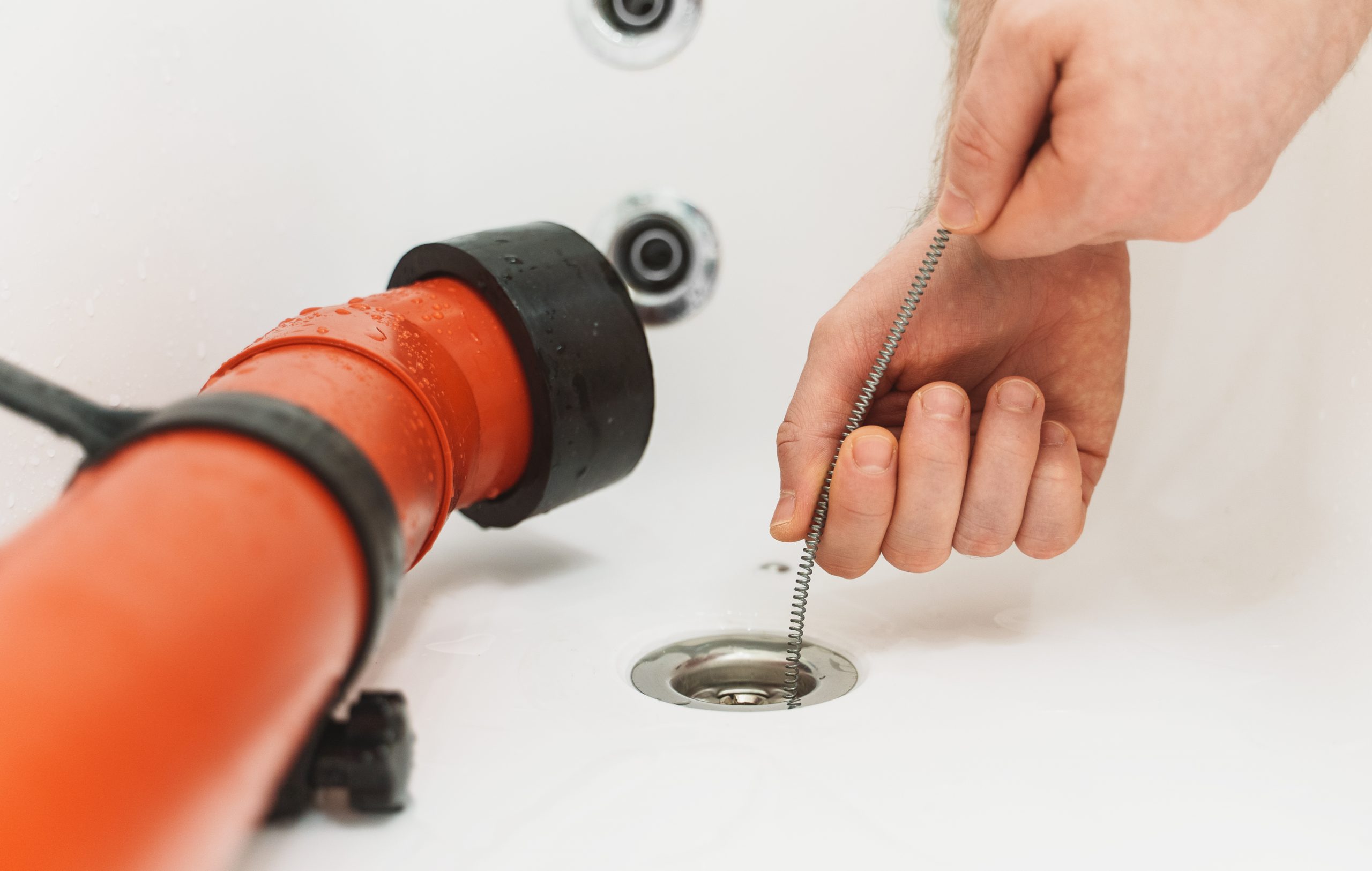 process of drain cleaning of the bathtub using special tools